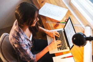 Woman writing a blog to help with marketing her business